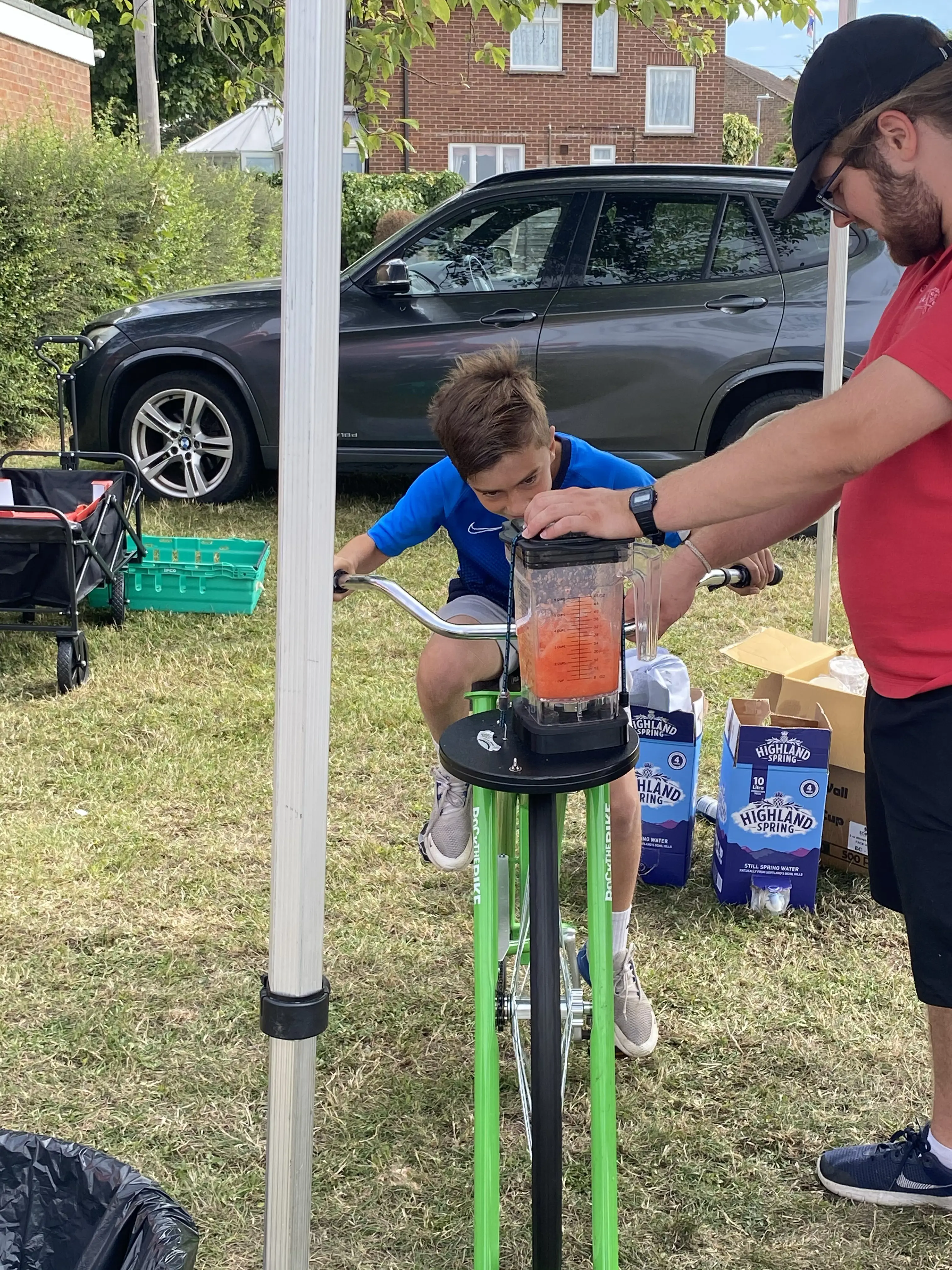 Boy riding bike attached to machine to make a fruit smoothie