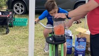 Boy riding bike attached to machine to make a fruit smoothie preview