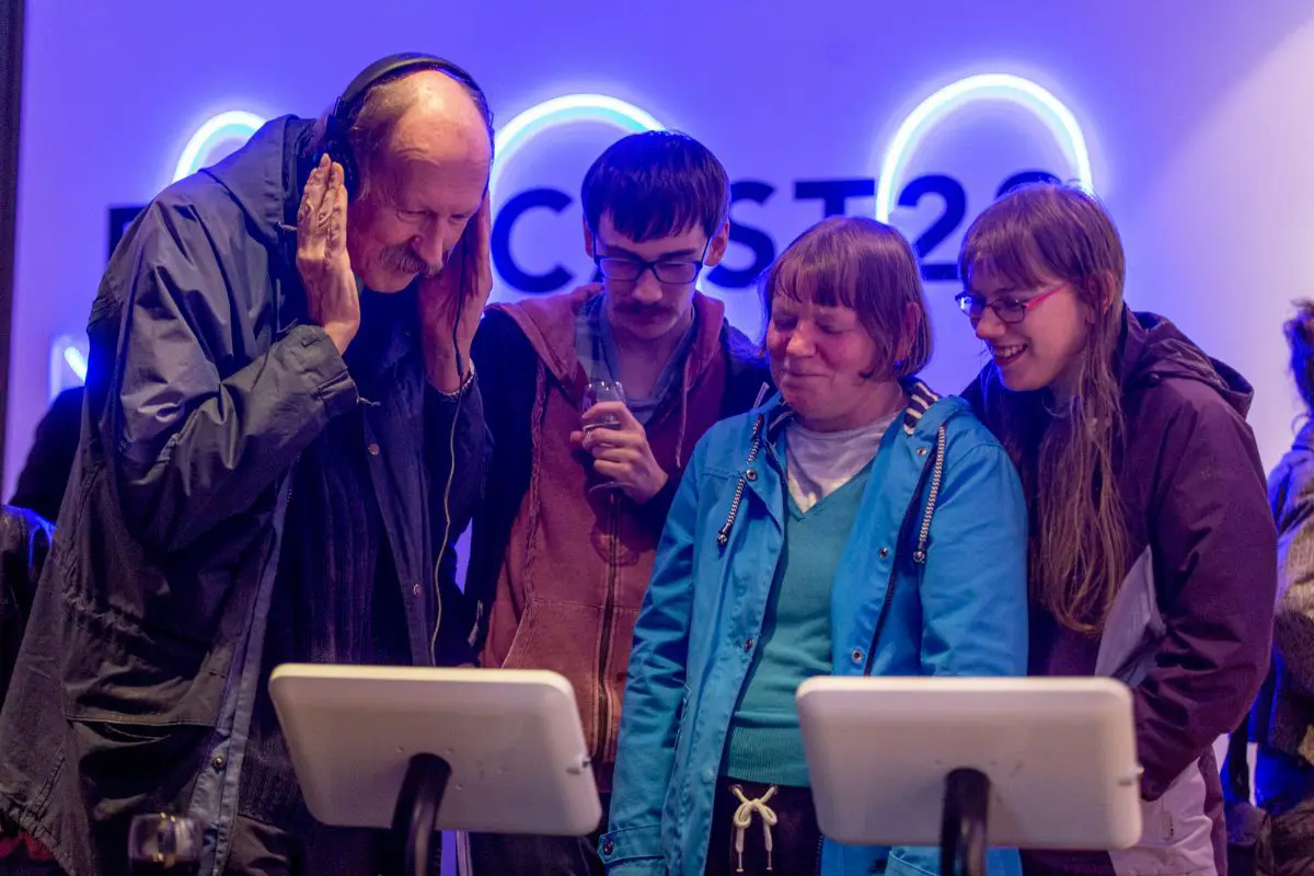 A family watching the digital exhibition on a tablet at the Forecast22 launch. 