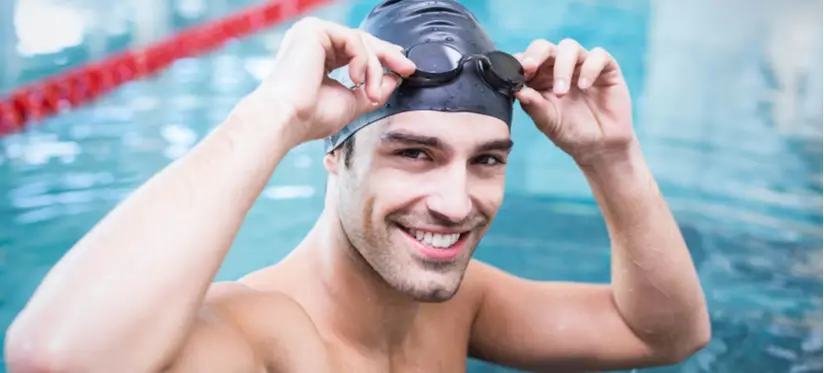 Smiling man in swimming cap with goggles