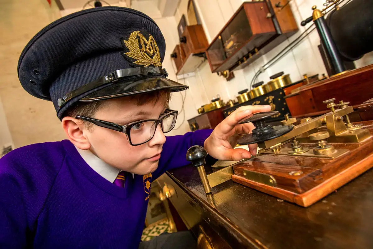 Young boy with a hat using a Morse code device. 