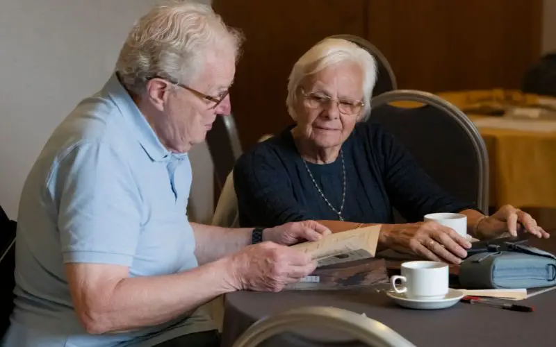 A man and woman looking at a book together. 