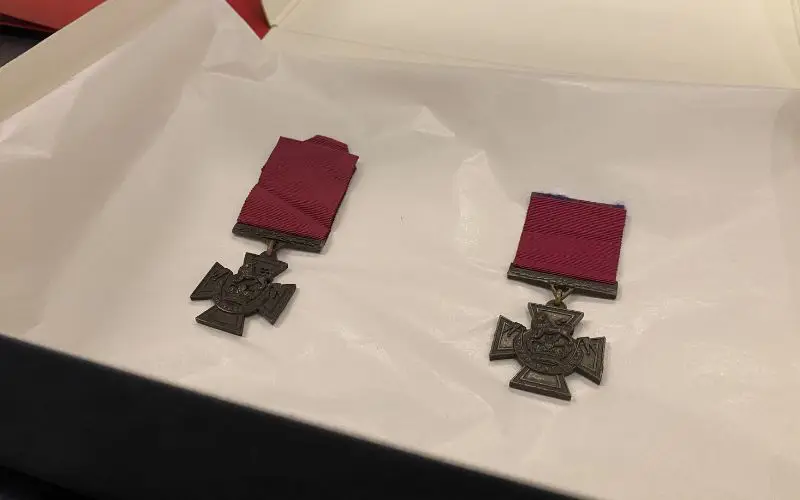 Two Victoria Cross medals lying on white tissue paper. 