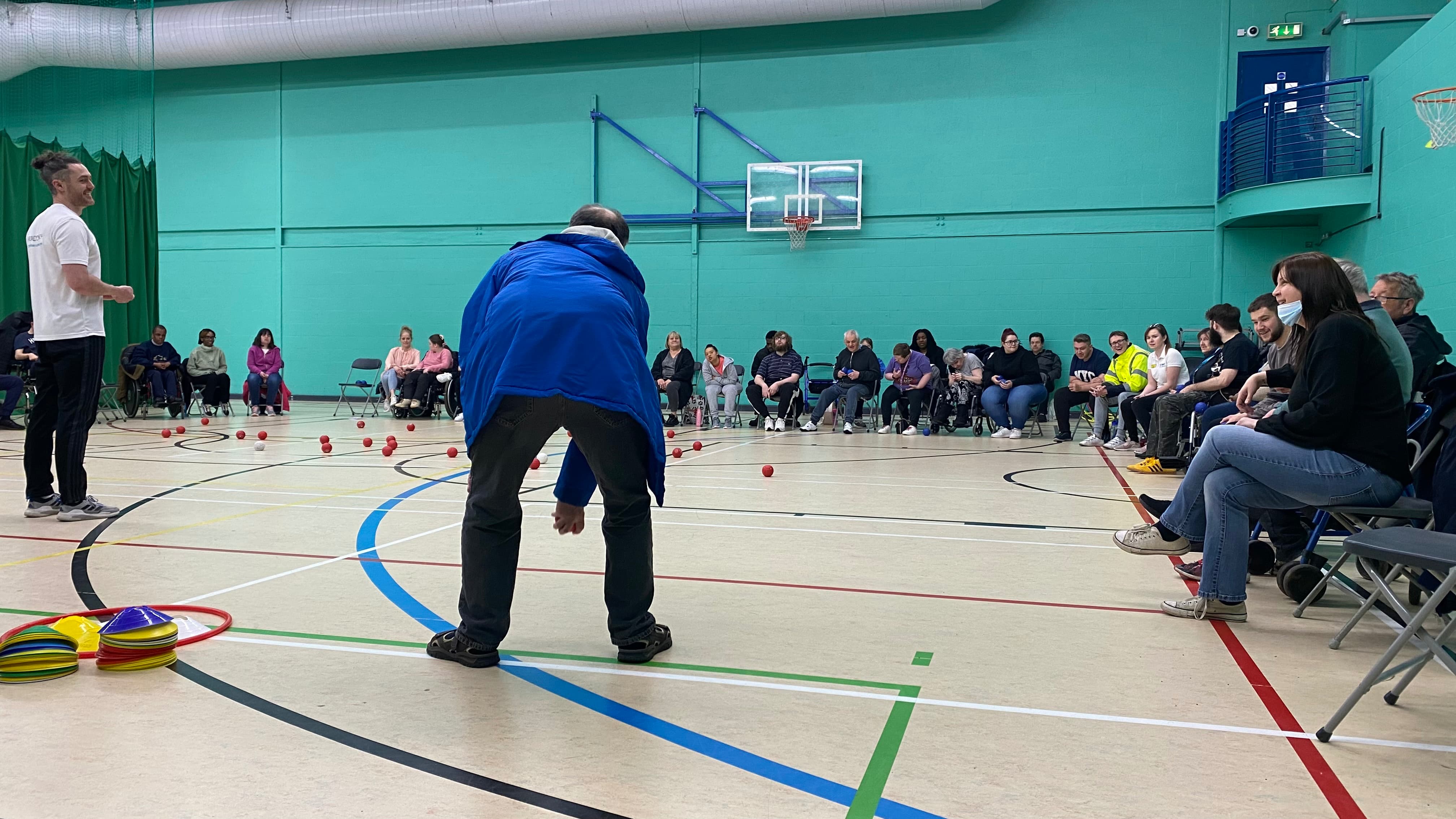 Man leaning over to throw a boccia ball preview