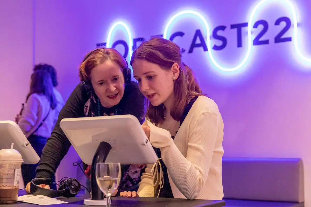 Two people looking at a tablet at the Forecast22 exhibition launch. 