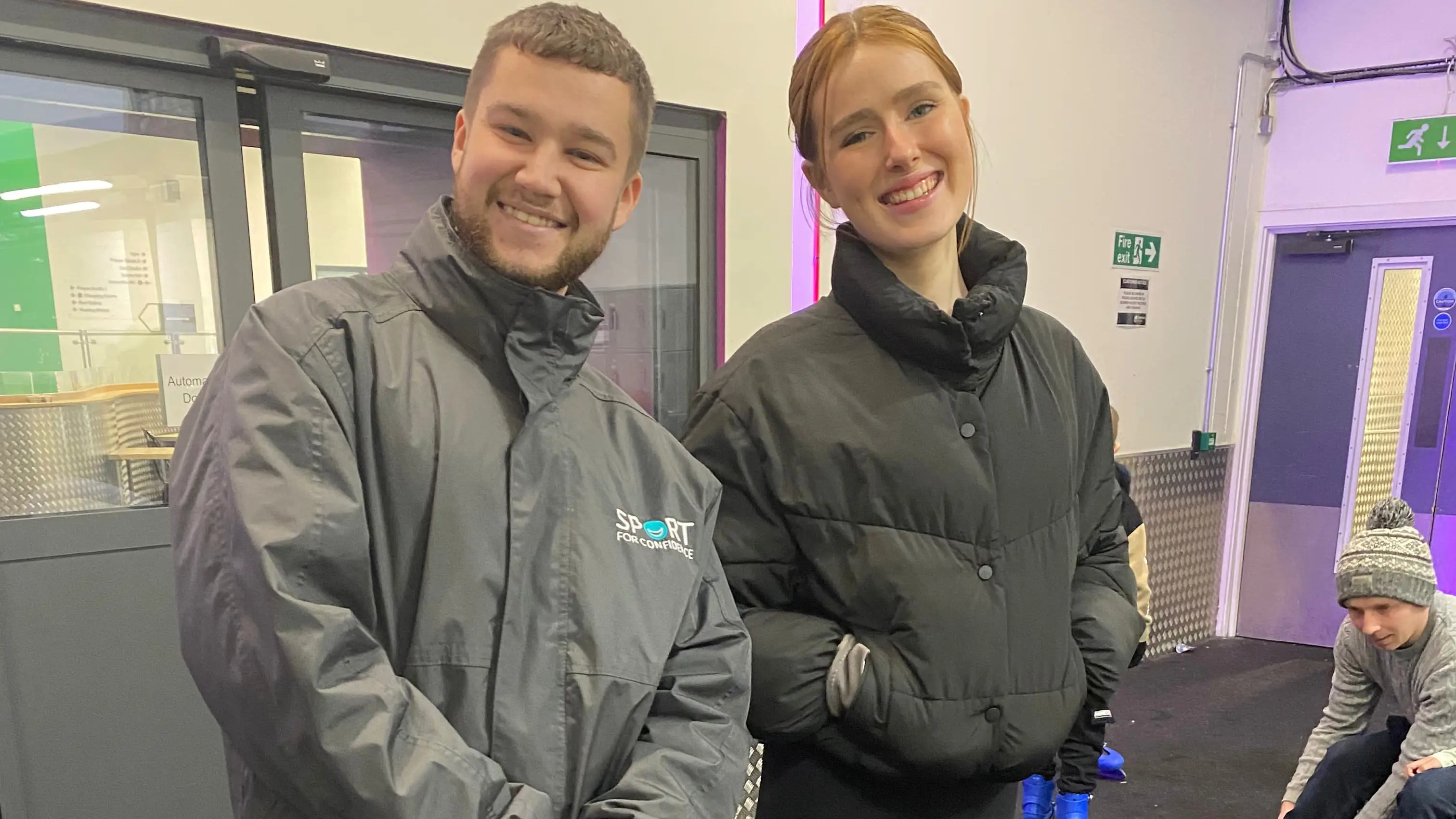 Two Sport for Confidence ice skating coaches stood side by side off-ice, smiling