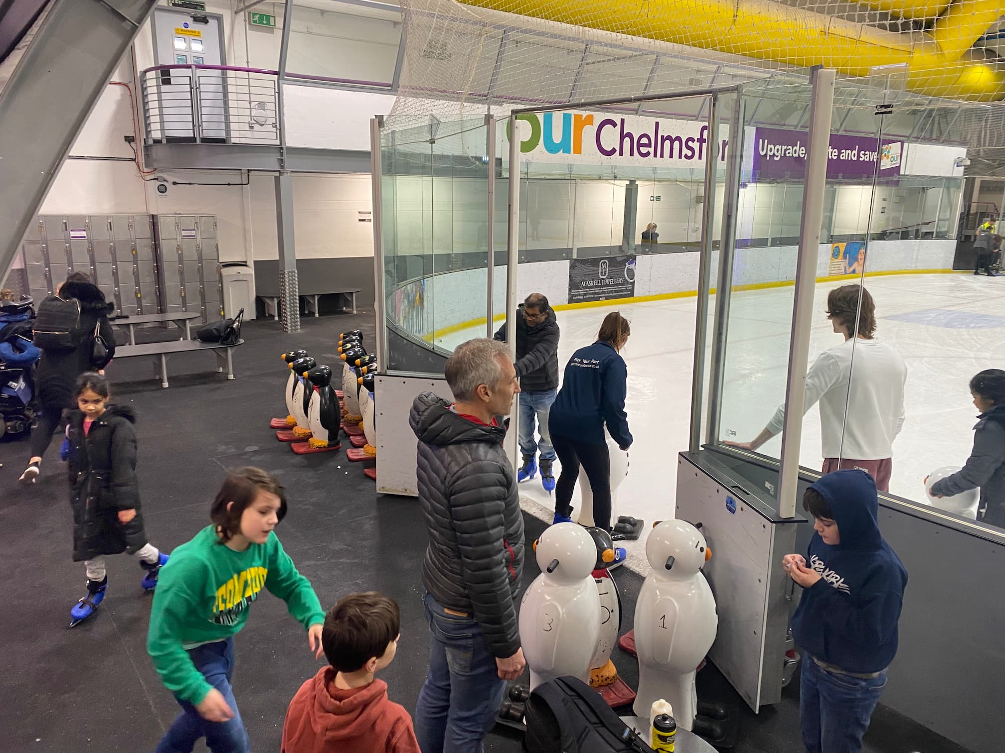 A small group of people entering an ice skating rink preview