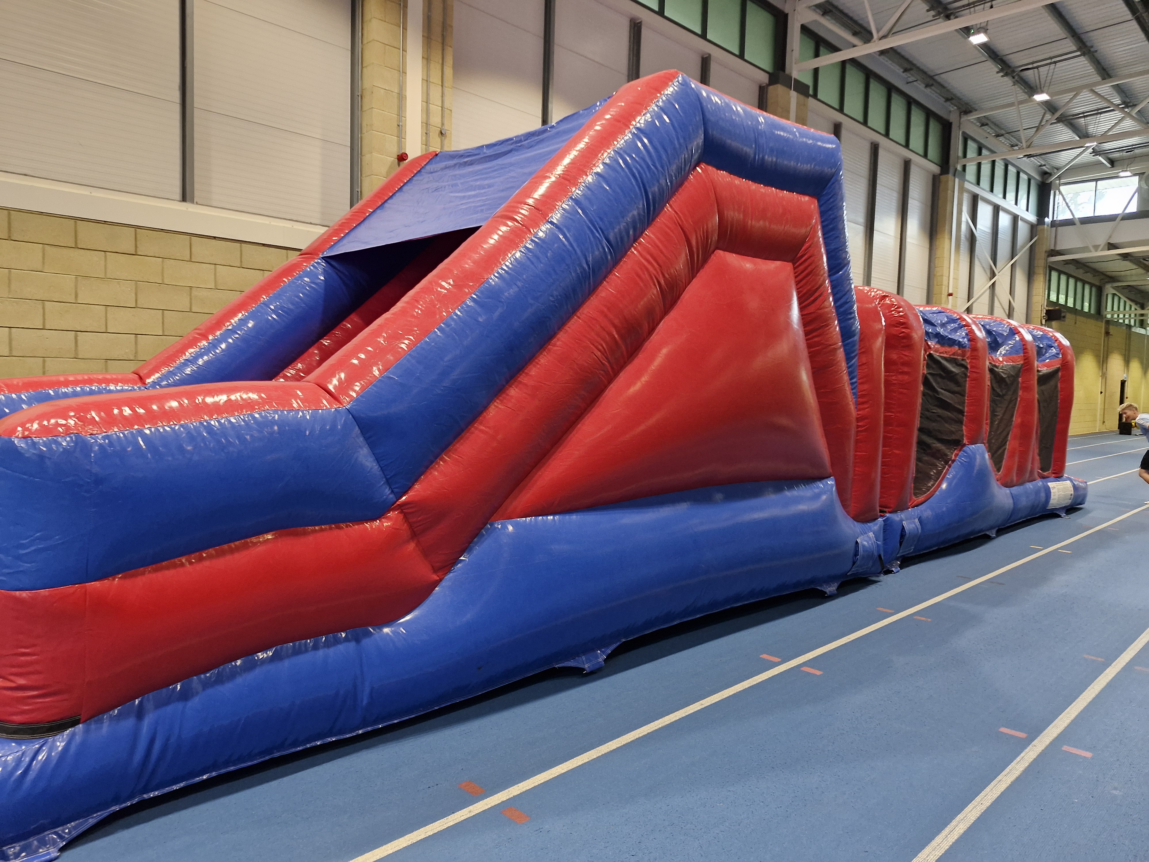 Large red and blue inflatable play equipment in sports hall