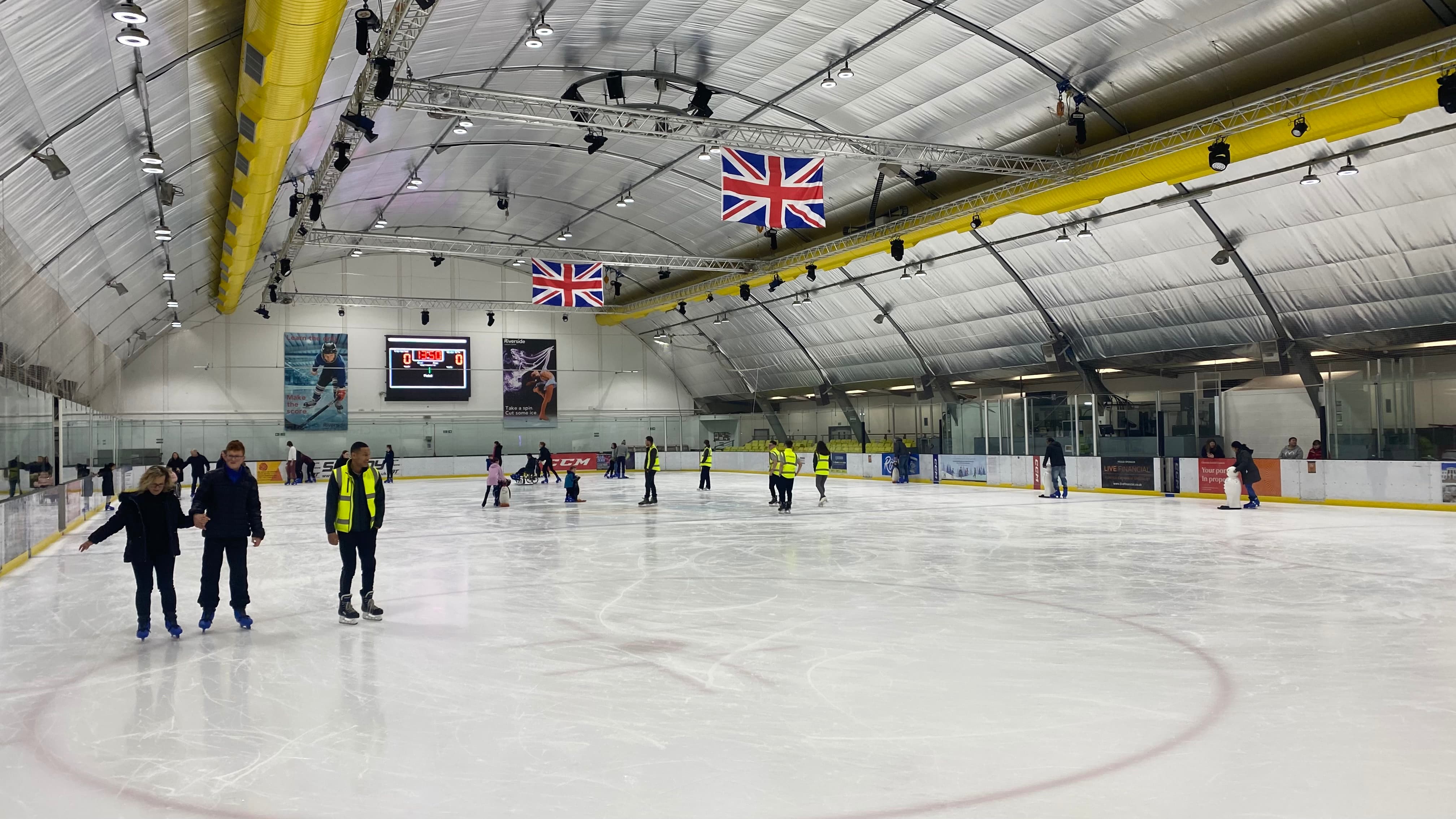 Group of people ice skating on an indoor ice rink preview