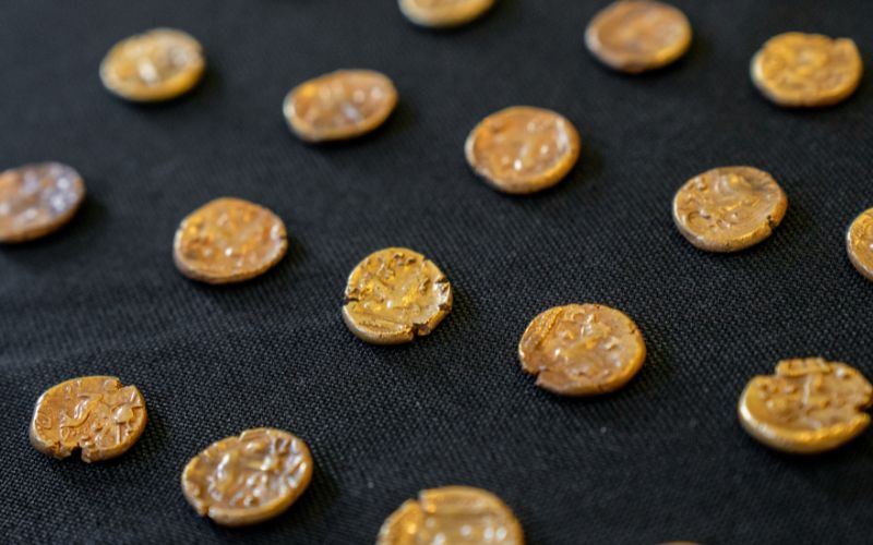 A close up of gold coins laid out on a table. 