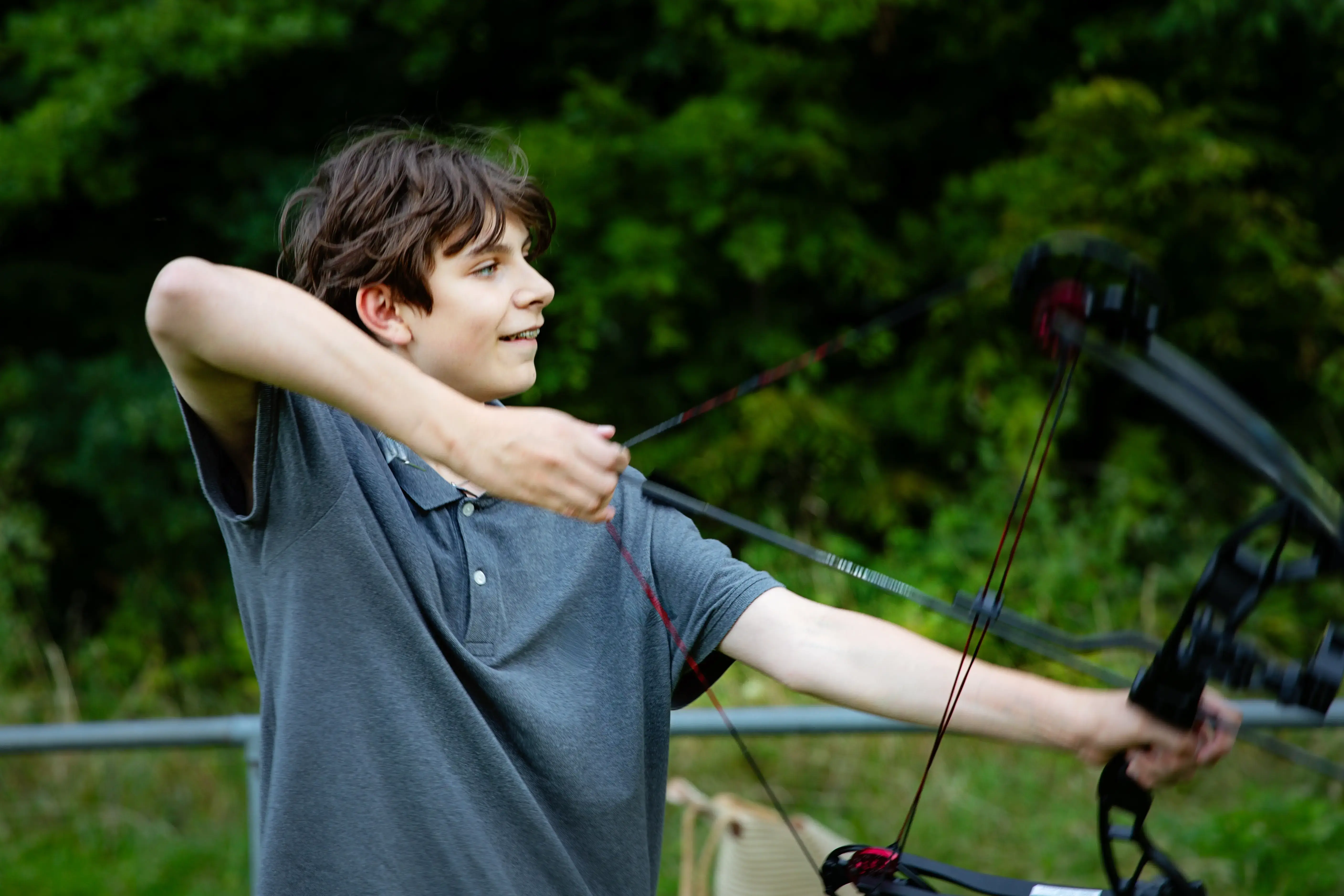 Older boy drawing back arrow in large black bow