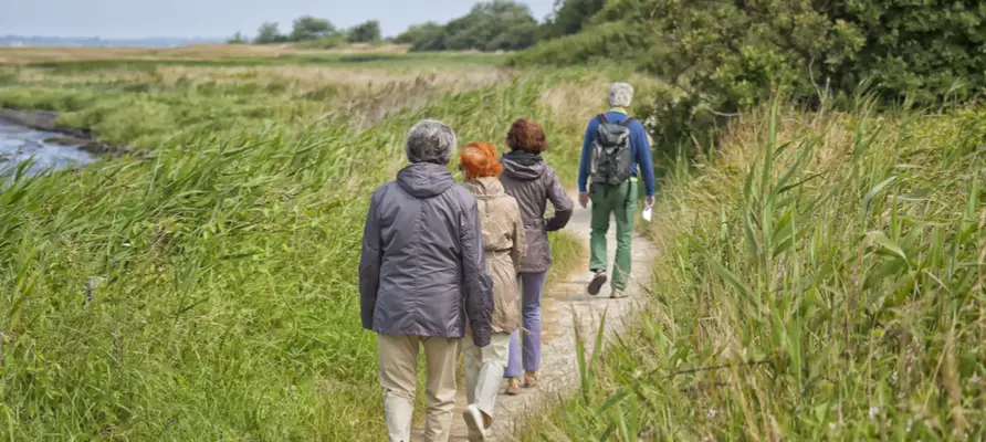 Man leading walkers along riverside walk