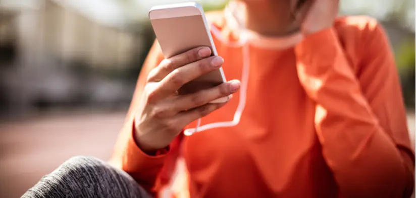Woman wearing orange top using smart phone