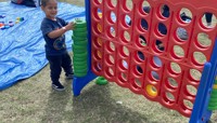 Boy playing with giant Connect 4 game preview