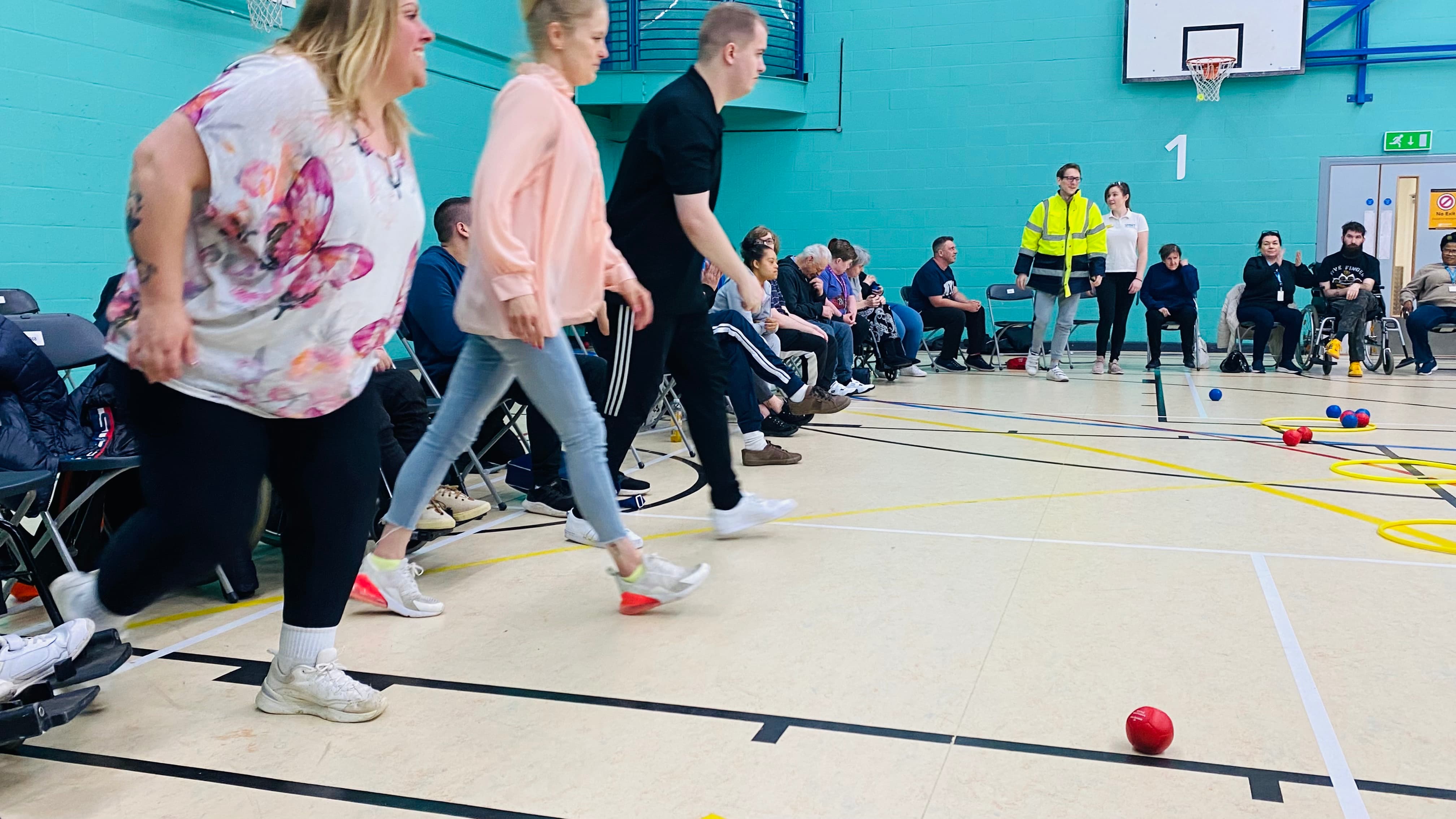 A group of people walking towards boccia balls preview