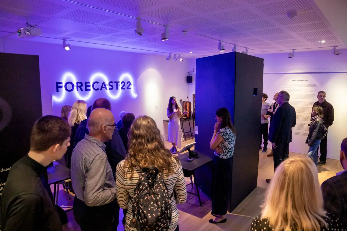 A group of people standing inside the temporary Forecast22 exhibition on its launch night. 