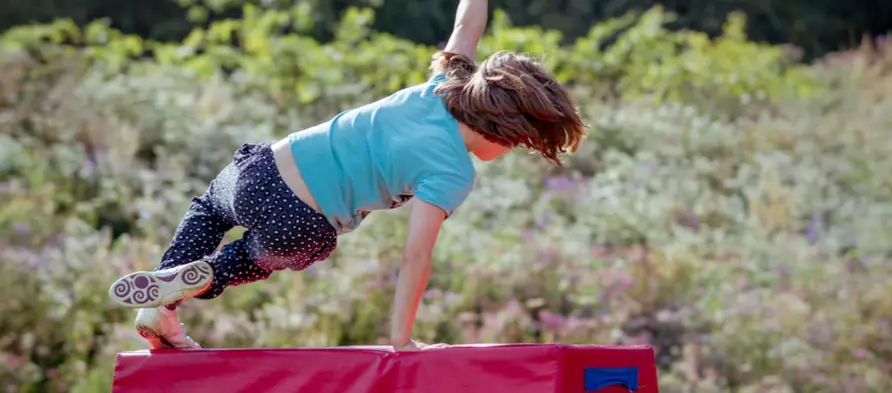Child leaping over obstacle