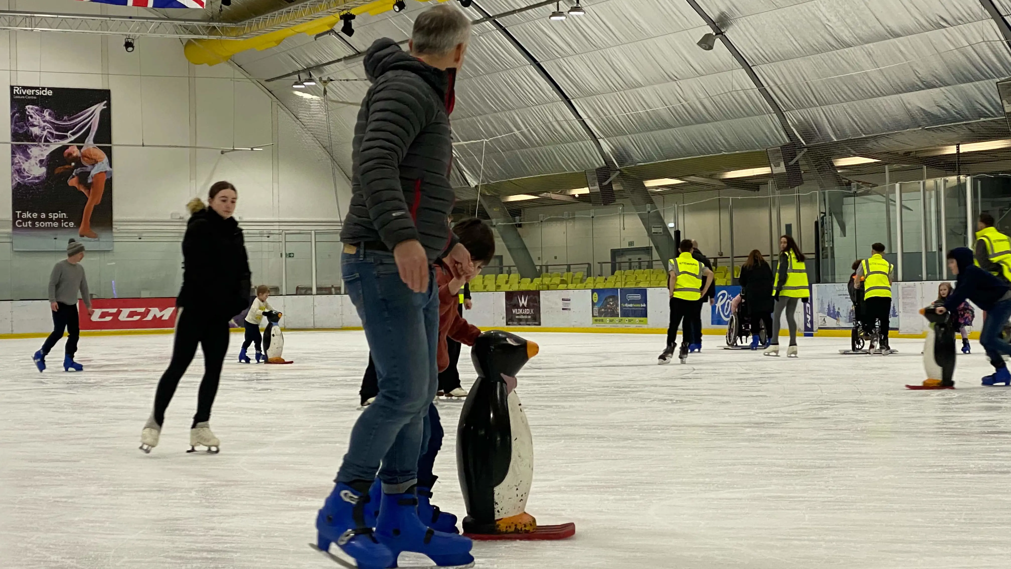 Father and daughter holding hands ice skating